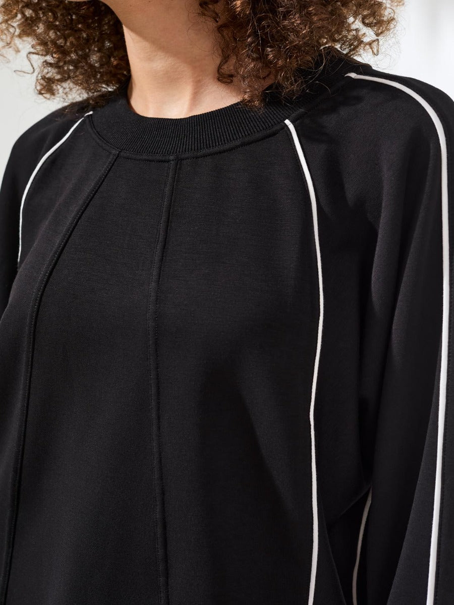 Close-up of black Tribal Techno Lux Piping Scuba Crew Top with white piping by Tribal Sportswear Inc.