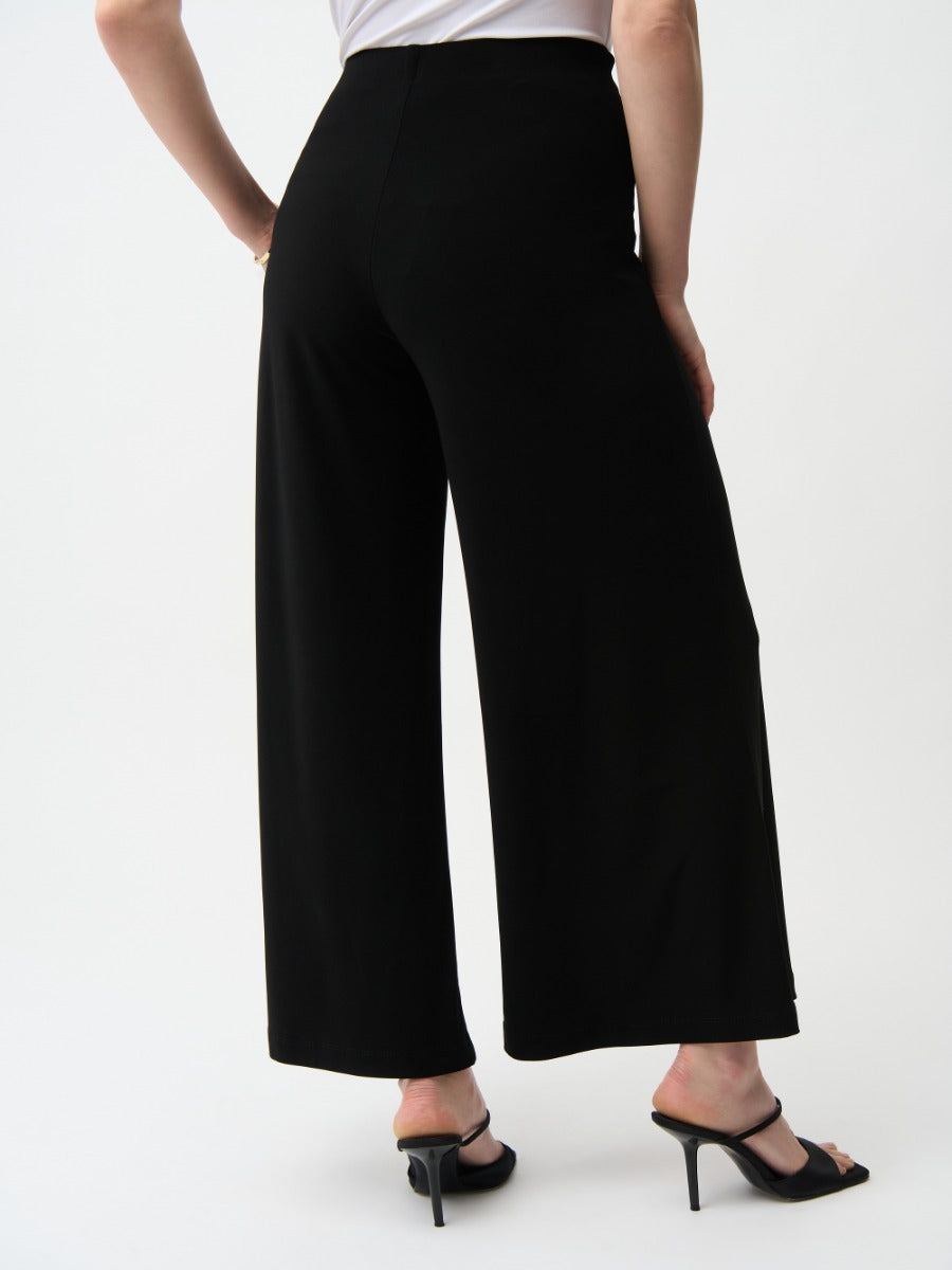 Back view of Joseph Ribkoff Polish Silky Knit 28" Wide Pant in black paired with black heeled sandals by Joseph Ribkoff
