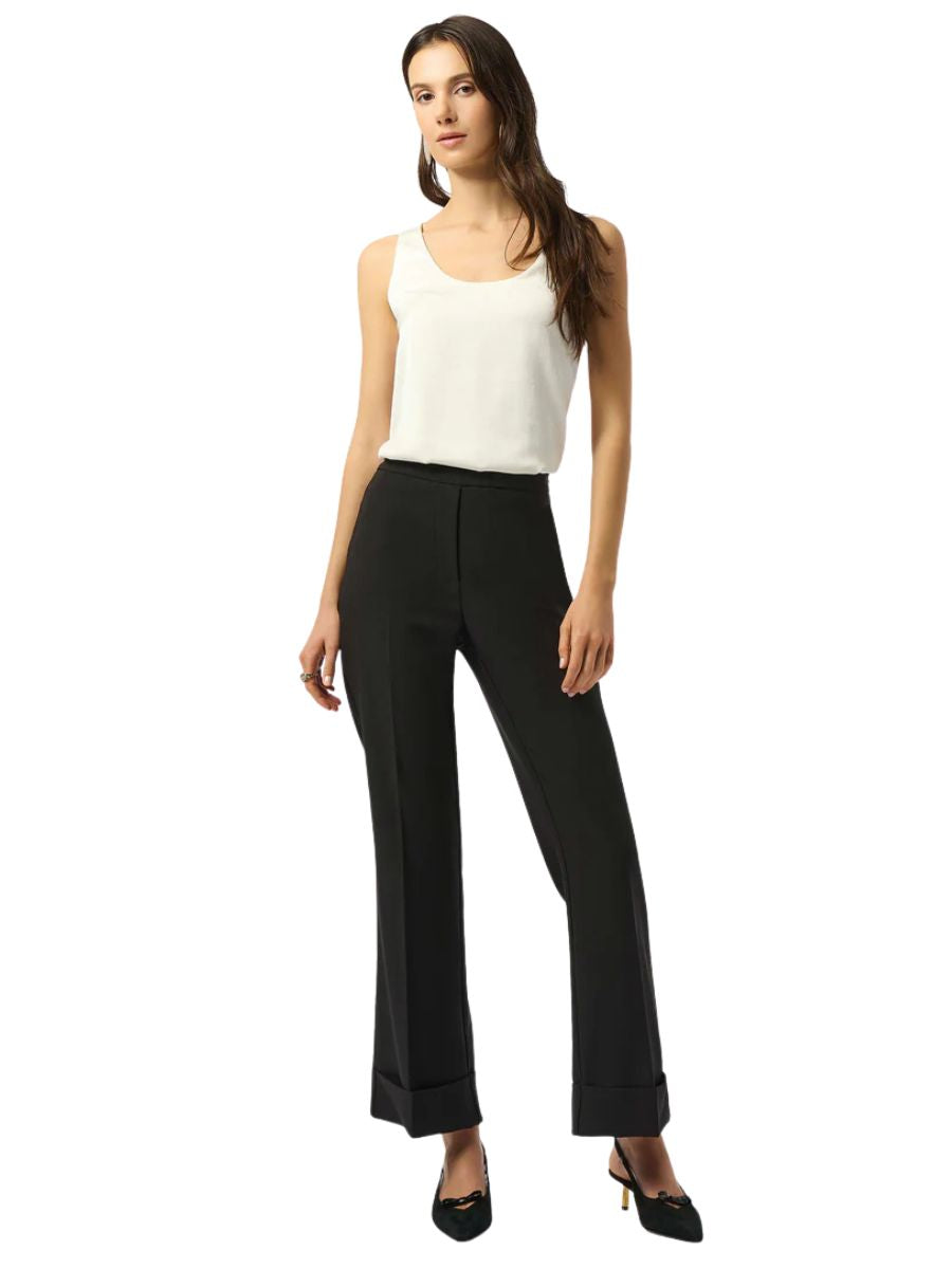 Slim fit black high-waisted pants paired with a white sleeveless top and black pointed heels on a white background.