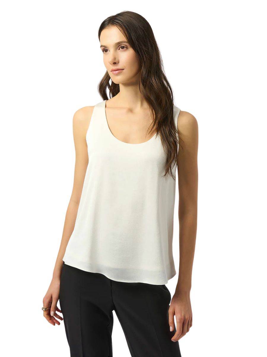 Elegant white satin sleeveless top by Joseph Ribkoff styled with black pants, ideal for sophisticated casual outfits.
