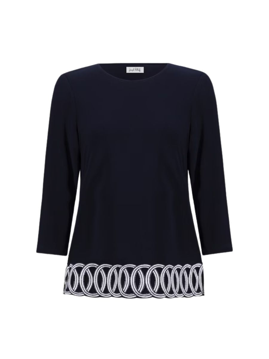 Navy blue long sleeve top with white embroidered loop pattern along the hemline and a round neckline.