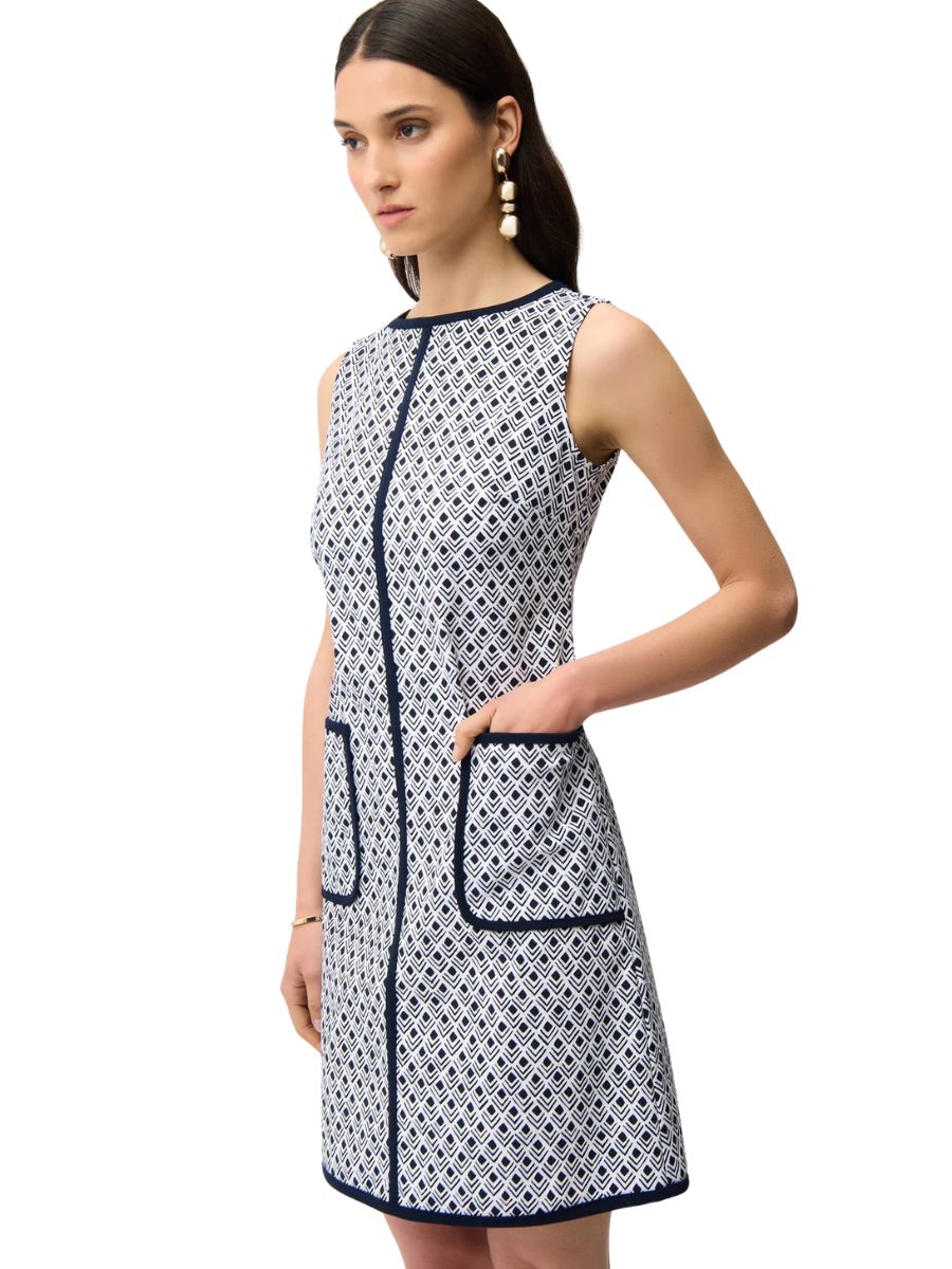 Sleeveless navy and white patterned dress with front pockets and contrast trim worn by a model with long dark hair.