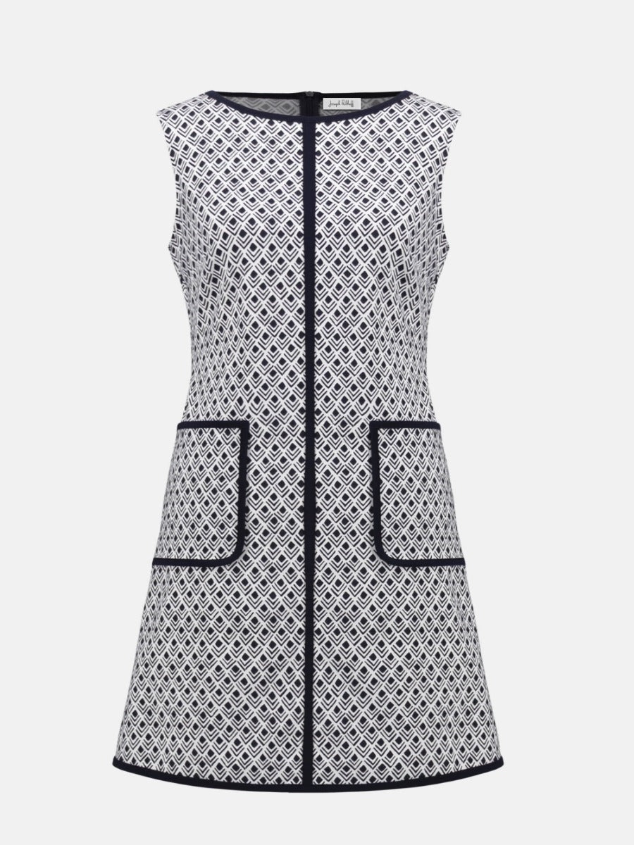 Sleeveless A-line dress with black and white geometric pattern and black trim on pockets, neckline, and hem.