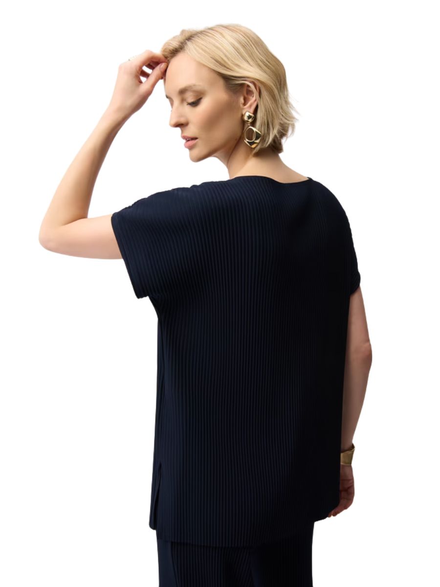 Blonde model in a navy ribbed short-sleeve top with side slits and large geometric gold earrings.