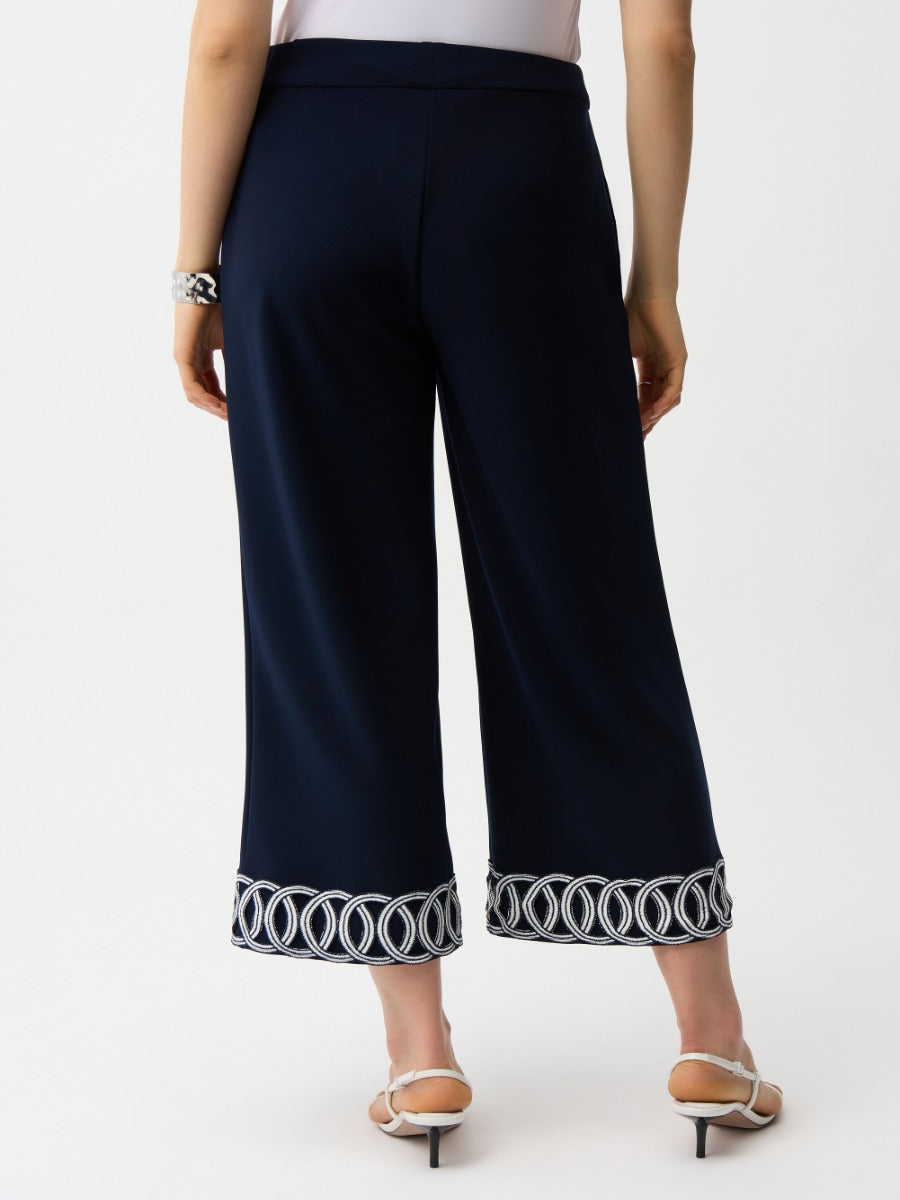 Back view of navy Joseph Ribkoff Suit and Tache 26" Crop Pant with white embroidered hem detailing and bracelet accessory