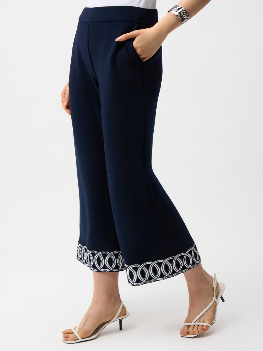 Joseph Ribkoff Suit and Tache 26" Crop Pant in navy with embroidered hem styled with white strappy heels.