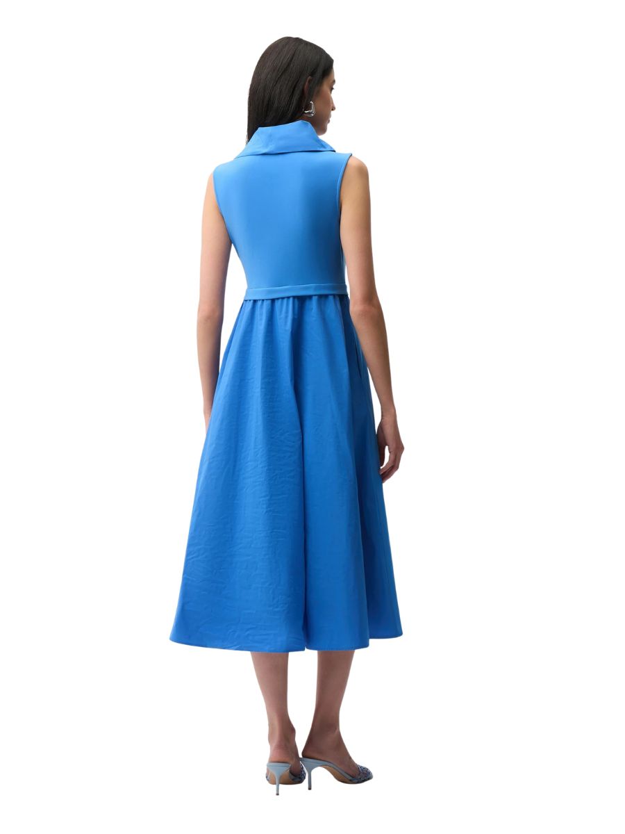 Back view of a sleeveless blue midi dress with a wide collar and flared skirt worn with heeled sandals.