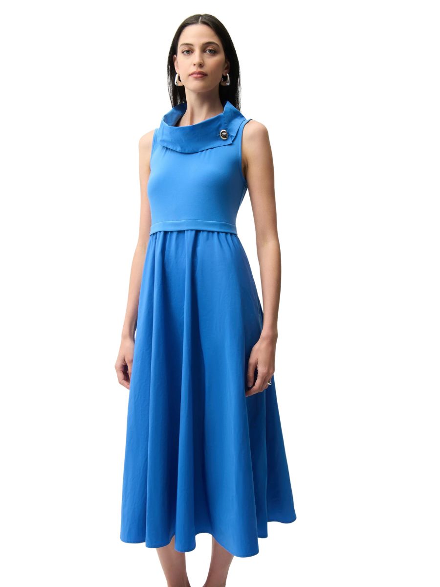 Sleeveless blue midi dress with a draped collar and button detail on one side worn by a model with hoop earrings