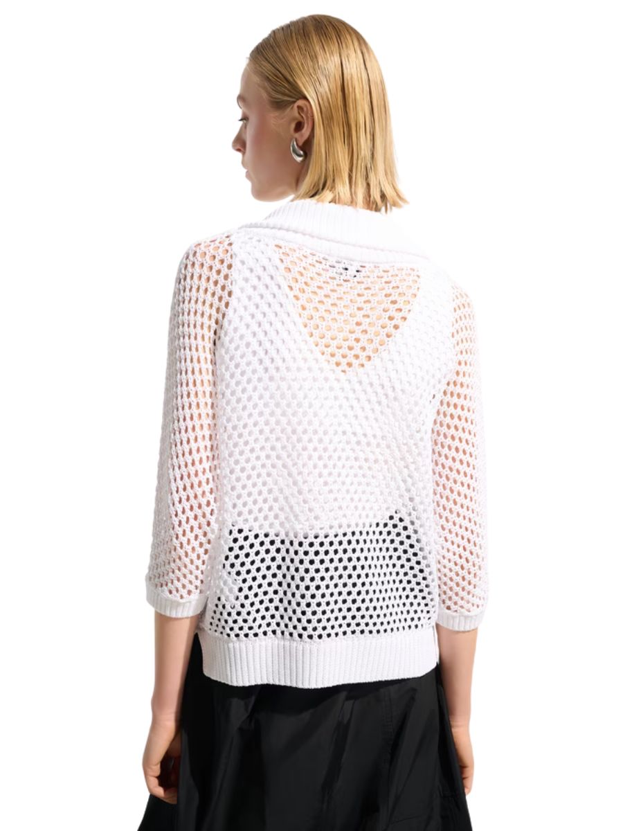Back view of a person wearing a white open-knit sweater with three-quarter sleeves and a black skirt.