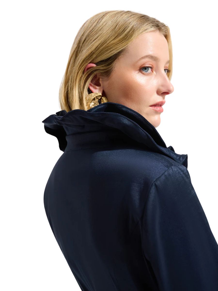 Light-skinned model in navy Joseph Ribkoff New Taffeta Dress featuring a high collar and gold statement earrings