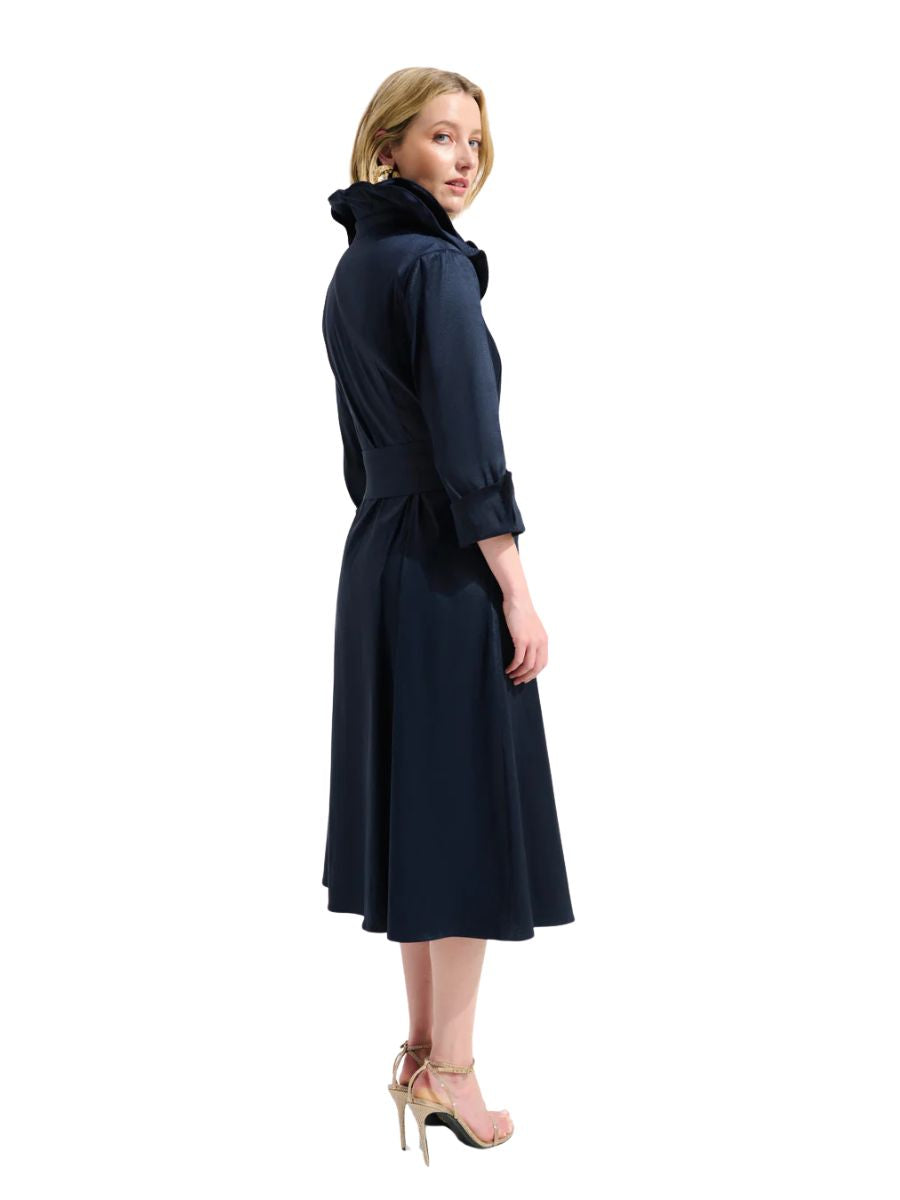 Person in a navy long-sleeve belted trench coat with high collar, standing against a white background.