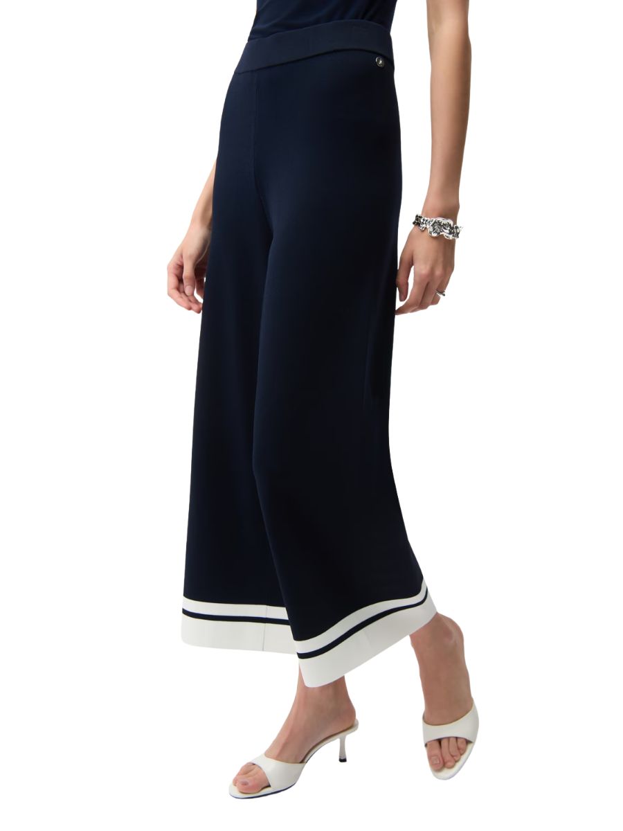 Navy wide-leg cropped pants with white and black striped hem, paired with white open-toe high heel sandals and a silver bracelet.