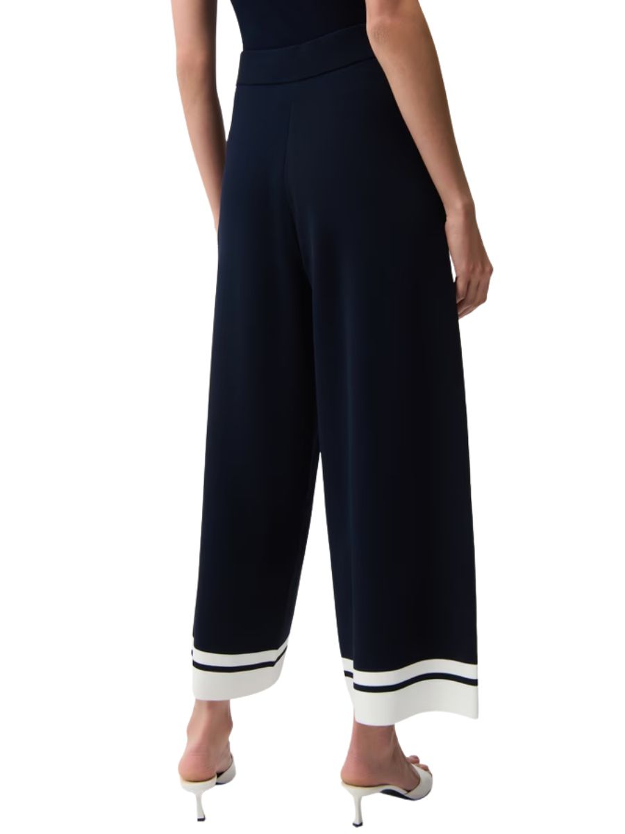 Navy wide-leg pants with white and black striped cuffs paired with white heeled sandals.