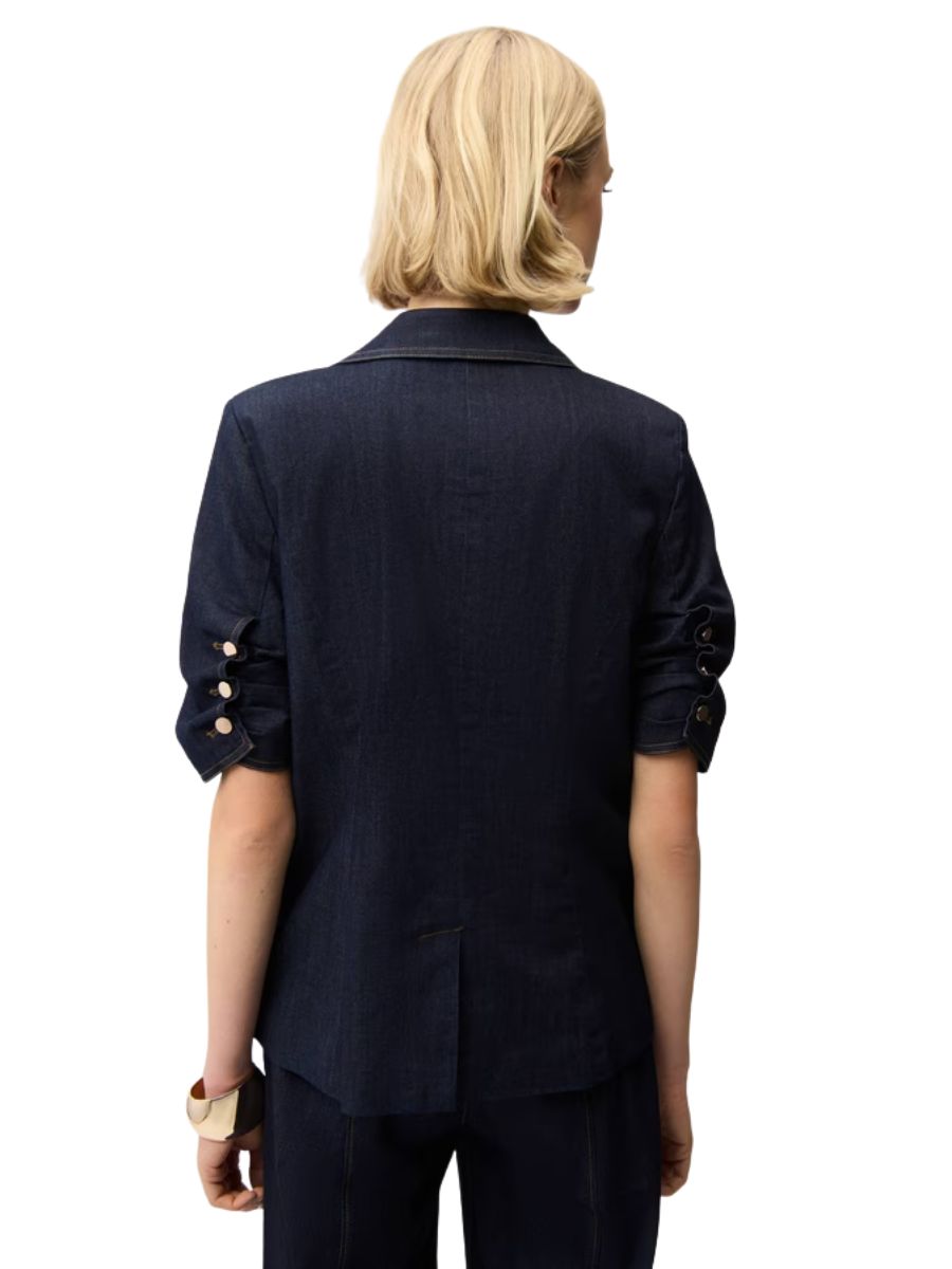 Back view of a dark denim blazer with ruched short sleeves by Joseph Ribkoff, named Joseph Ribkoff Playful Denim Stitch Short Sleeve Blazer.
