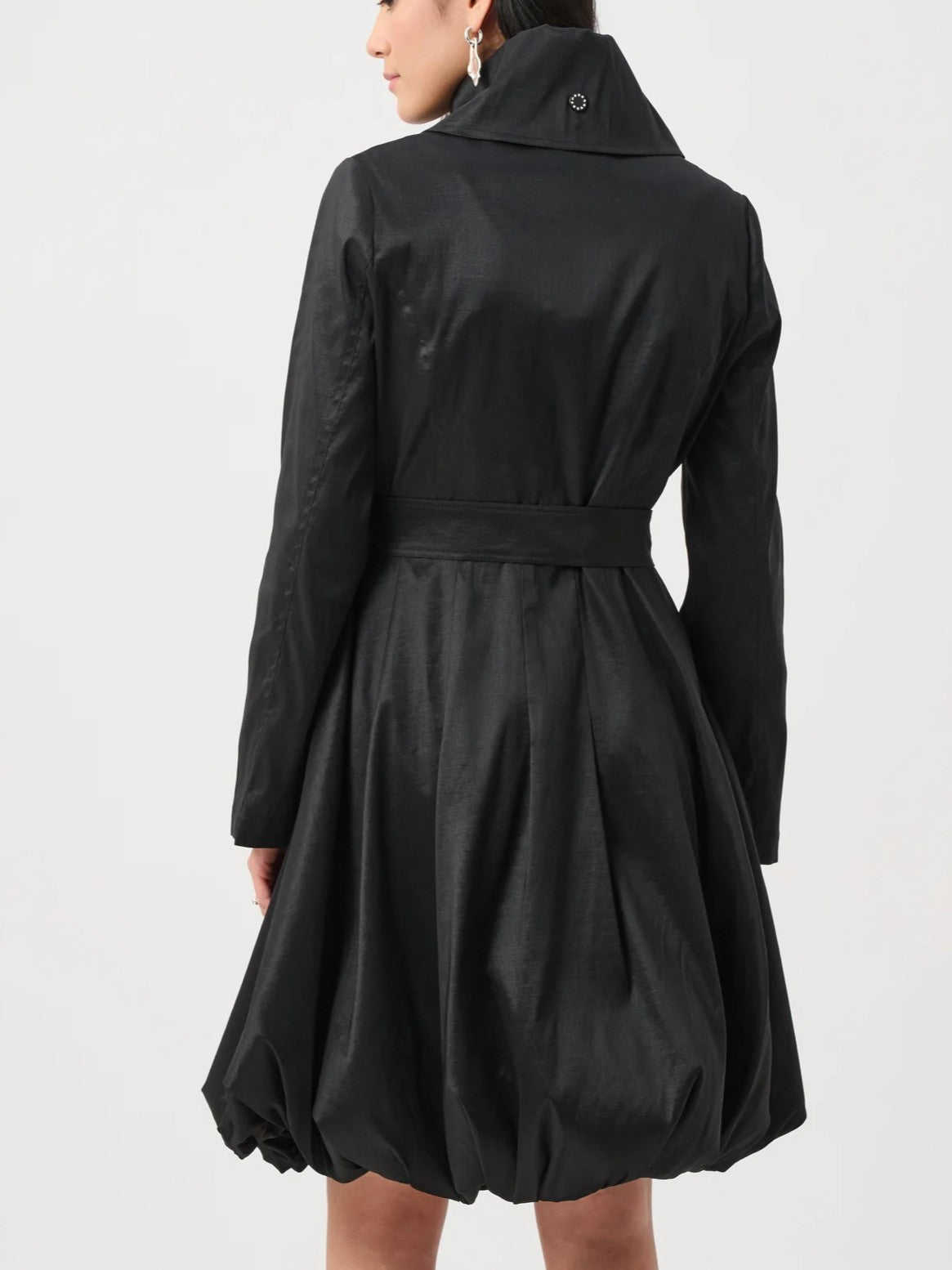 Back view of a black, long-sleeve coat with a high collar and a gathered flared skirt detail.
