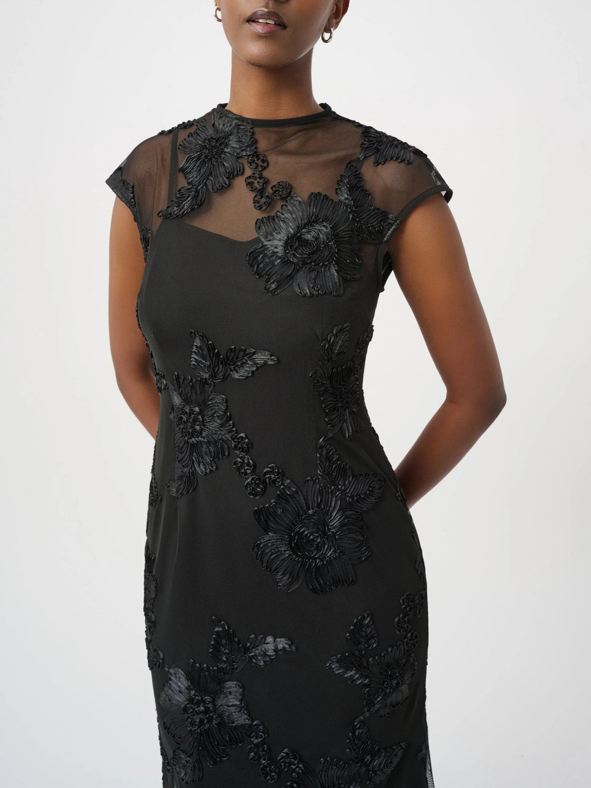 Black dress with sheer neckline and floral appliqué details on bodice and skirt
