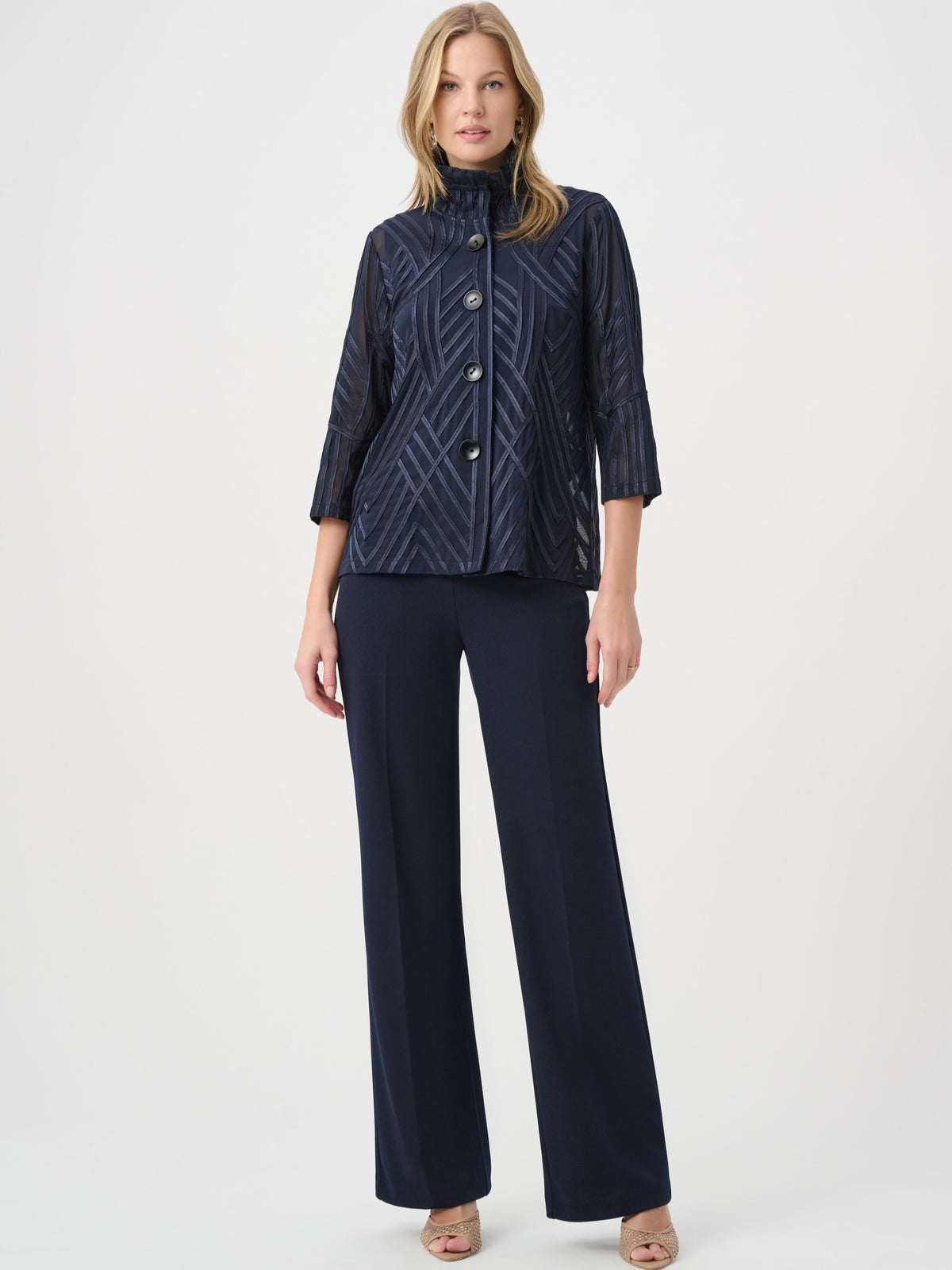 Navy blue sheer patterned jacket with buttons paired with matching wide-leg trousers and open-toe heels.