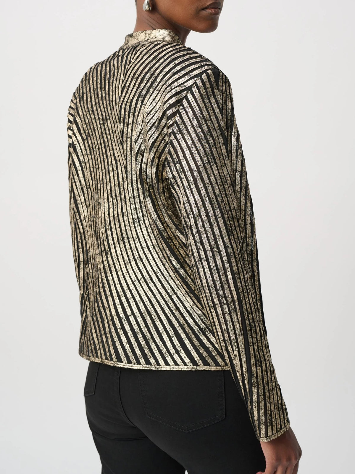 Metallic gold and black striped long-sleeve jacket paired with black fitted pants against a plain background.