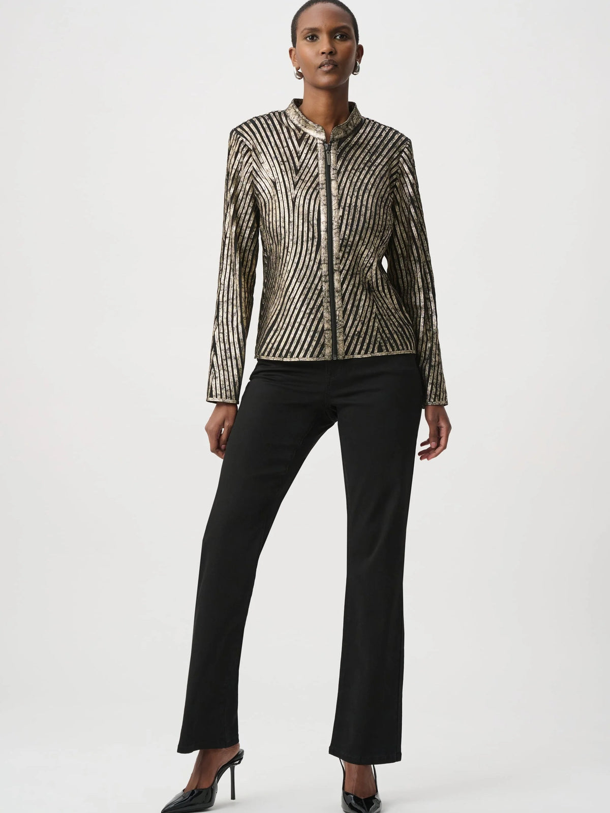Long-sleeve metallic striped jacket paired with black wide-leg pants and pointed high-heeled shoes on plain background.