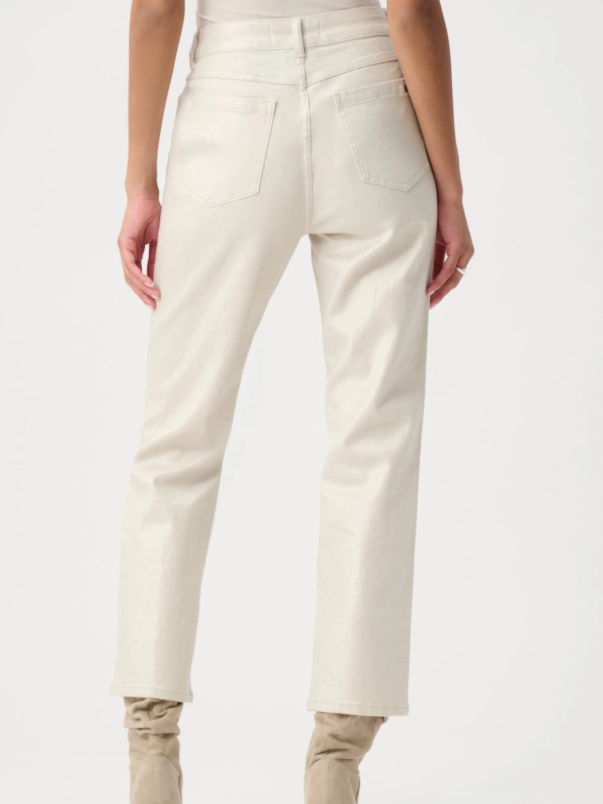 Back view of light beige denim jeans with back pockets and straight leg cut paired with beige boots.