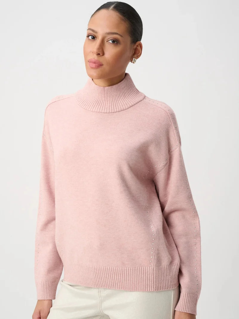 Pink ribbed turtleneck sweater with long sleeves and a relaxed fit, styled with light trousers