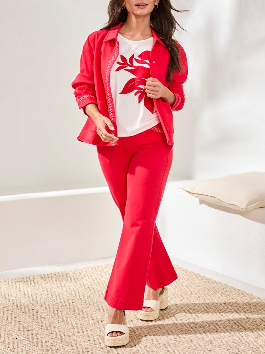 Bright red Tribal Playful Embroidered Detail Denim Jacket from Tribal Sportswear Inc. paired with matching pants and white shoes.