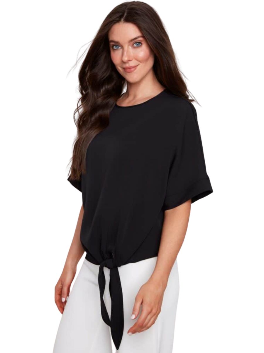 Black UP Penelope Vegan Silk Tie Knot Top by Up with short sleeves and front tie detail paired with white pants