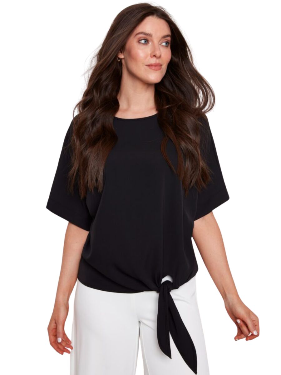 Black UP Penelope Vegan Silk Tie Knot Top from Up paired with white pants, styled with loose waves and hoop earrings.