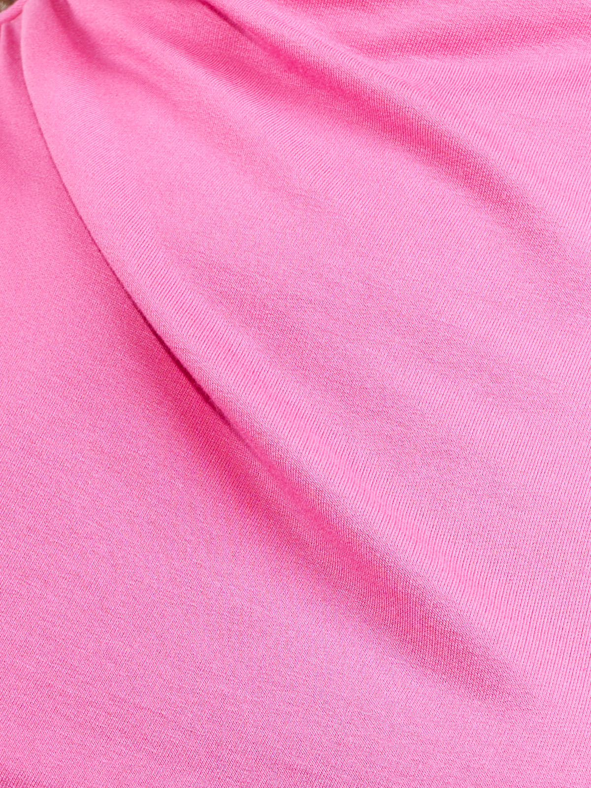 Close-up of smooth pink fabric with gentle folds and a soft texture.
