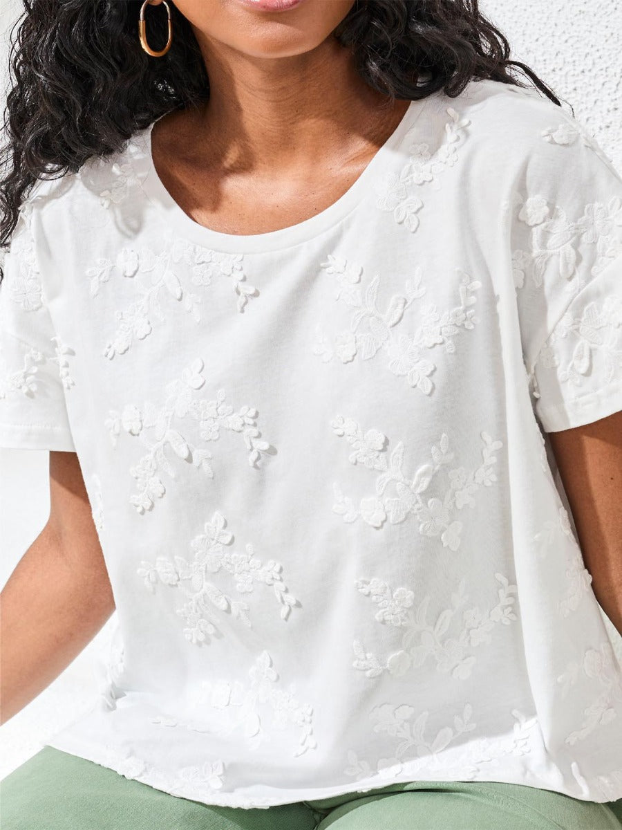 Close-up of a white Tribal Boho Bloom Embroidered Cotton Short Sleeve Top by Tribal Sportswear Inc. with floral details
