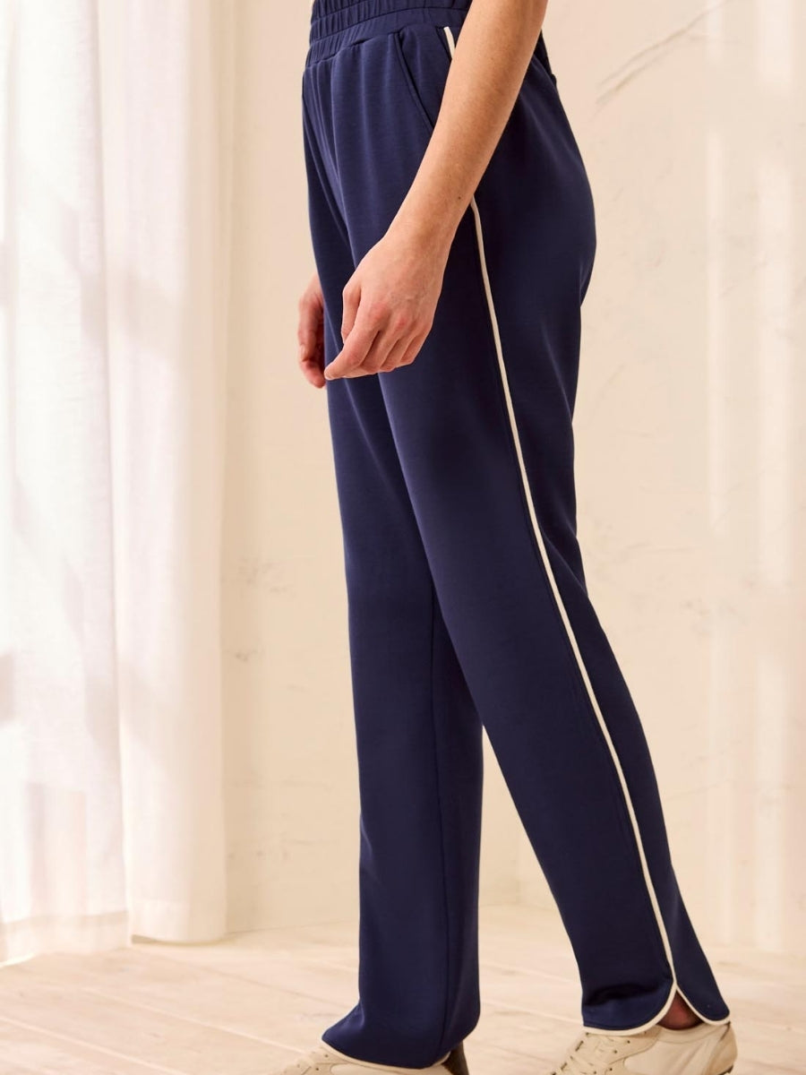 Navy blue trousers with white side stripe detail and elastic waistband, shown from the side view.