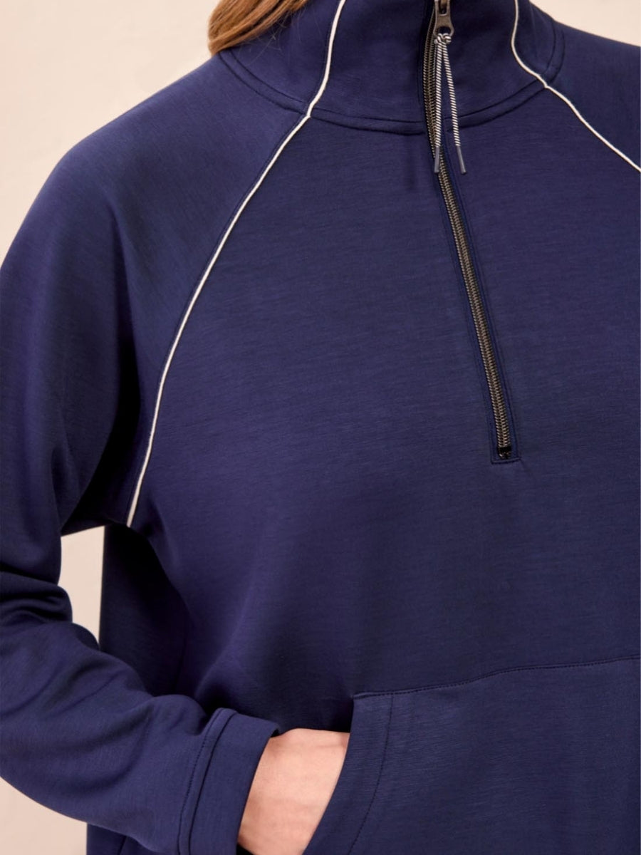 Navy blue high-neck pullover with white piping details and a front zipper, featuring a kangaroo pocket.