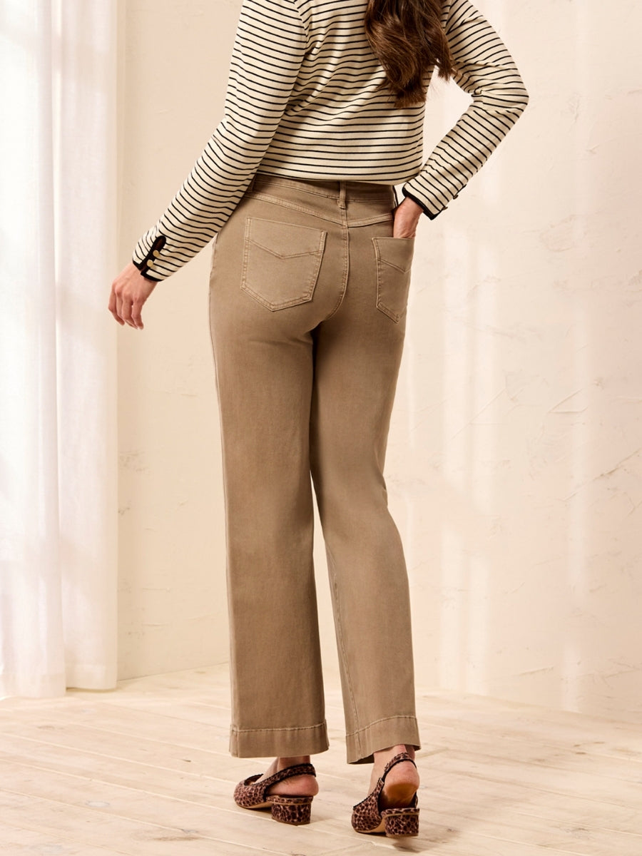 Rear view of light brown straight-leg pants paired with a black and white striped long-sleeve top and heeled sandals
