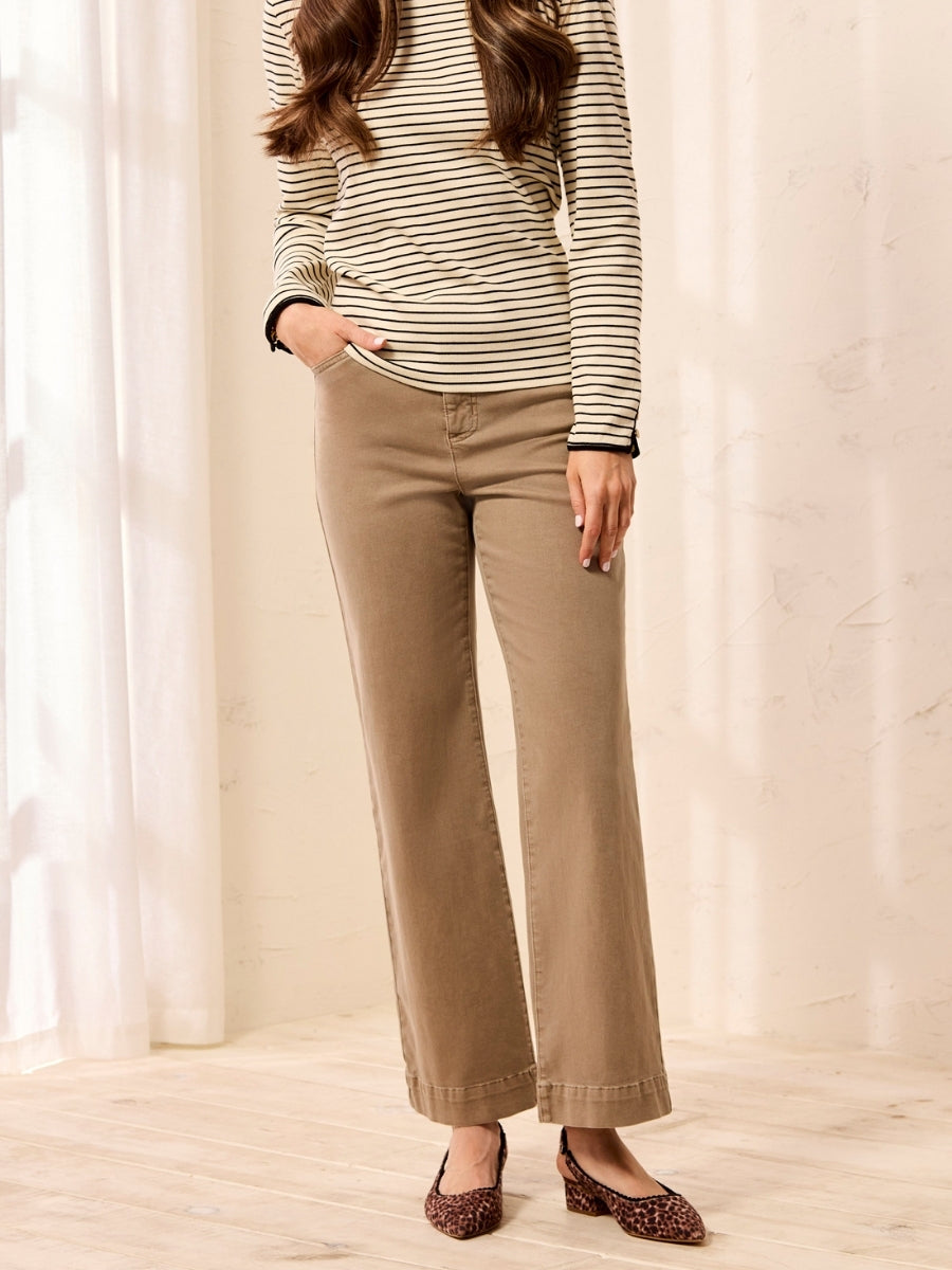 Lower body view of light brown wide-leg pants paired with a striped long-sleeve top and leopard print shoes.
