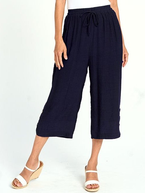 Navy Button Hem Linen Look Pull-On Pant by Red Coral with elastic waist and cropped wide legs, styled with white wedge sandals.