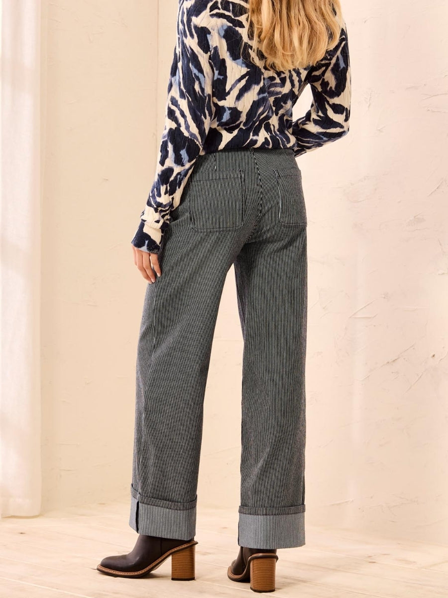 Person in striped wide-leg pants with cuffed hems, animal print long-sleeve top, and brown heeled ankle boots.