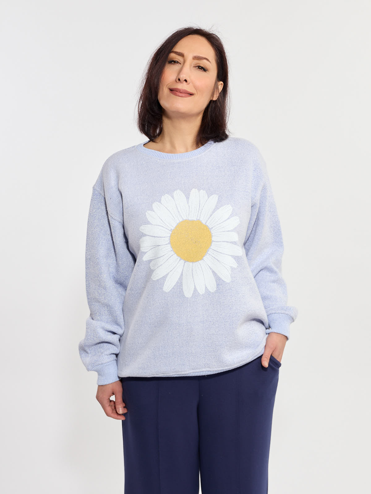 Light blue Women’s Daisy Graphic Nantucket Crewneck Sweatshirt by Win.E with large daisy print and navy pants.