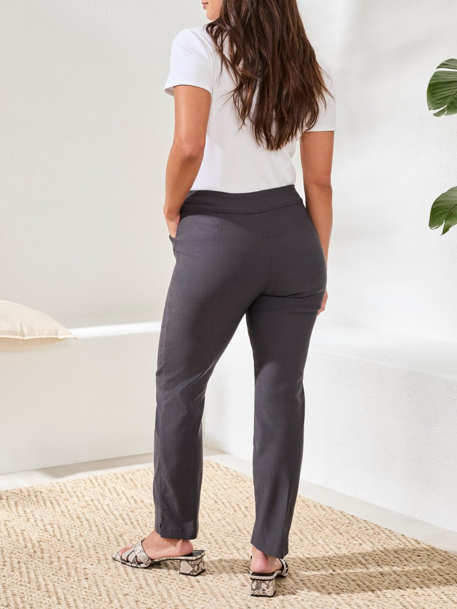 Rear view of black Tribal Performance Stretch Flatten 28” Pants by Tribal Sportswear Inc. in a bright room setting
