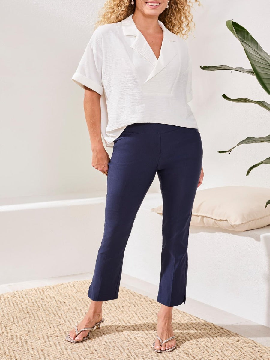 Tribal Performance Stretch Flatten 28” Pants in navy by Tribal Sportswear Inc. styled with a white top and sandals