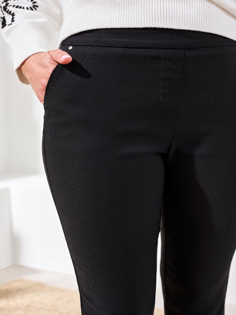 Close-up of black Tribal Flatten It® Slimming 22" Capri Pants by Tribal Sportswear Inc. with hand in pocket.
