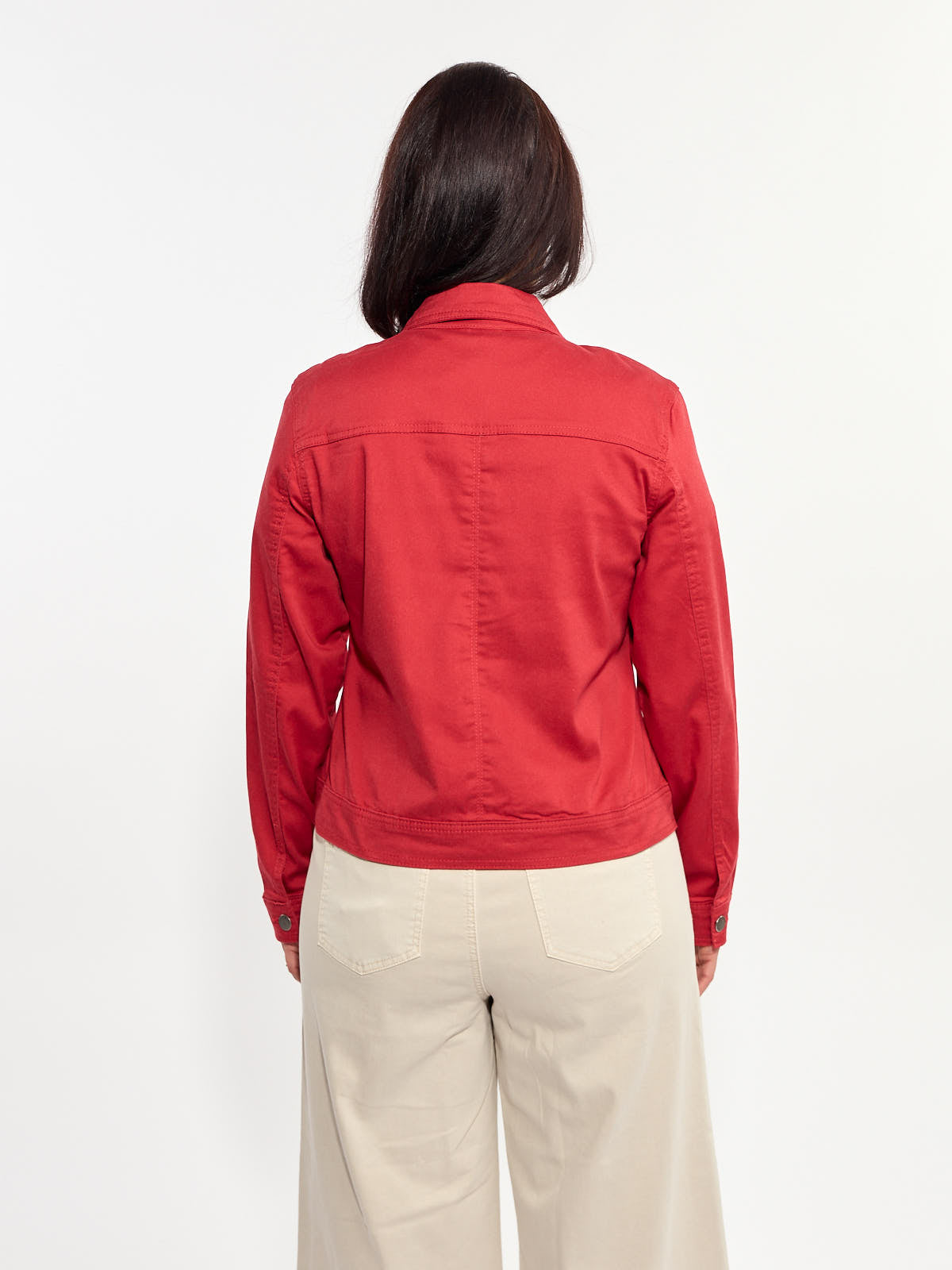 Back view of a red denim jacket paired with light beige wide-leg pants on a plain background.