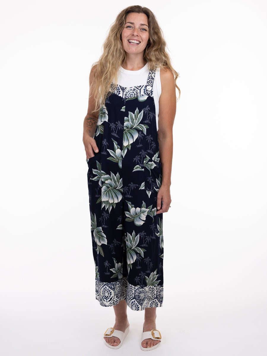 Smiling model in a floral patterned Shannon Passero Elora Print Overall by SHANNON PASSERO INC with pockets and white sandals