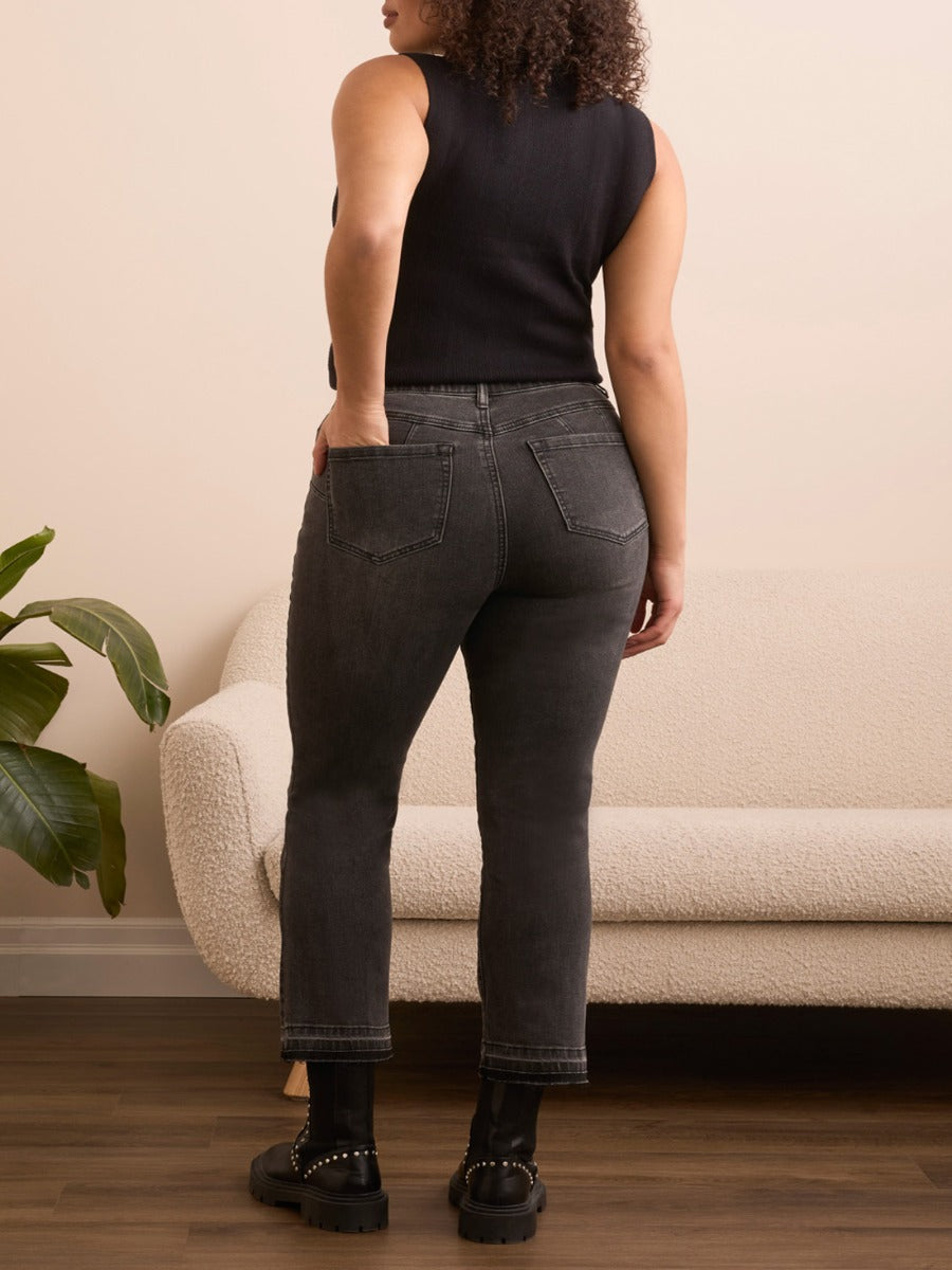 Back view of black Tribal Sophia Flare 26" Denim Pants by Tribal Sportswear Inc. styled with black boots and sleeveless top.