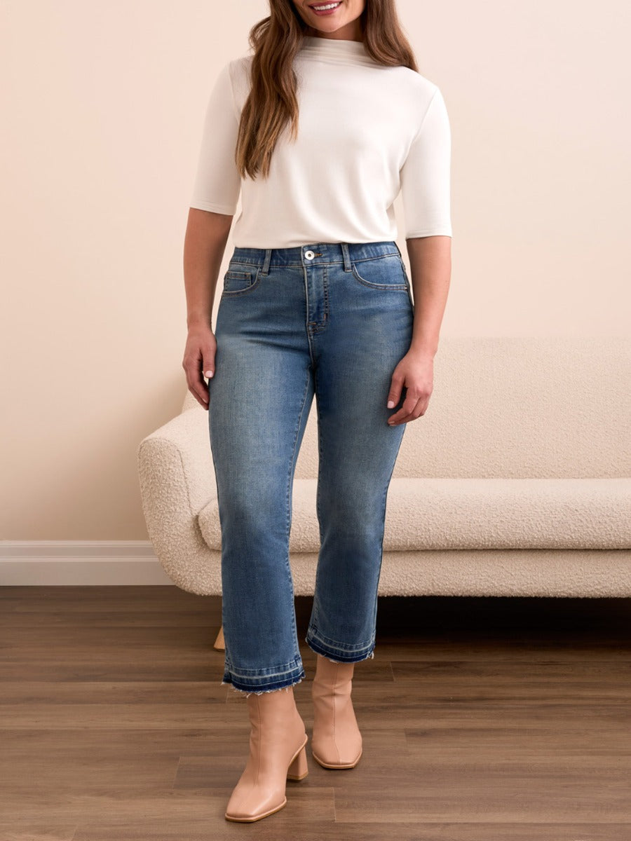 Tribal Sophia Flare 26" Denim Pants in medium wash by Tribal Sportswear Inc. styled with beige boots and white top