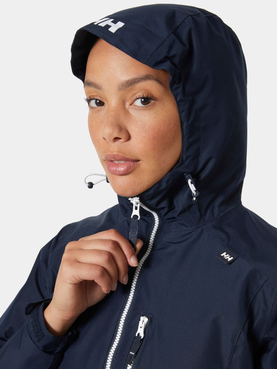 Close-up of a navy blue waterproof jacket with hood and white zipper details on a light background.