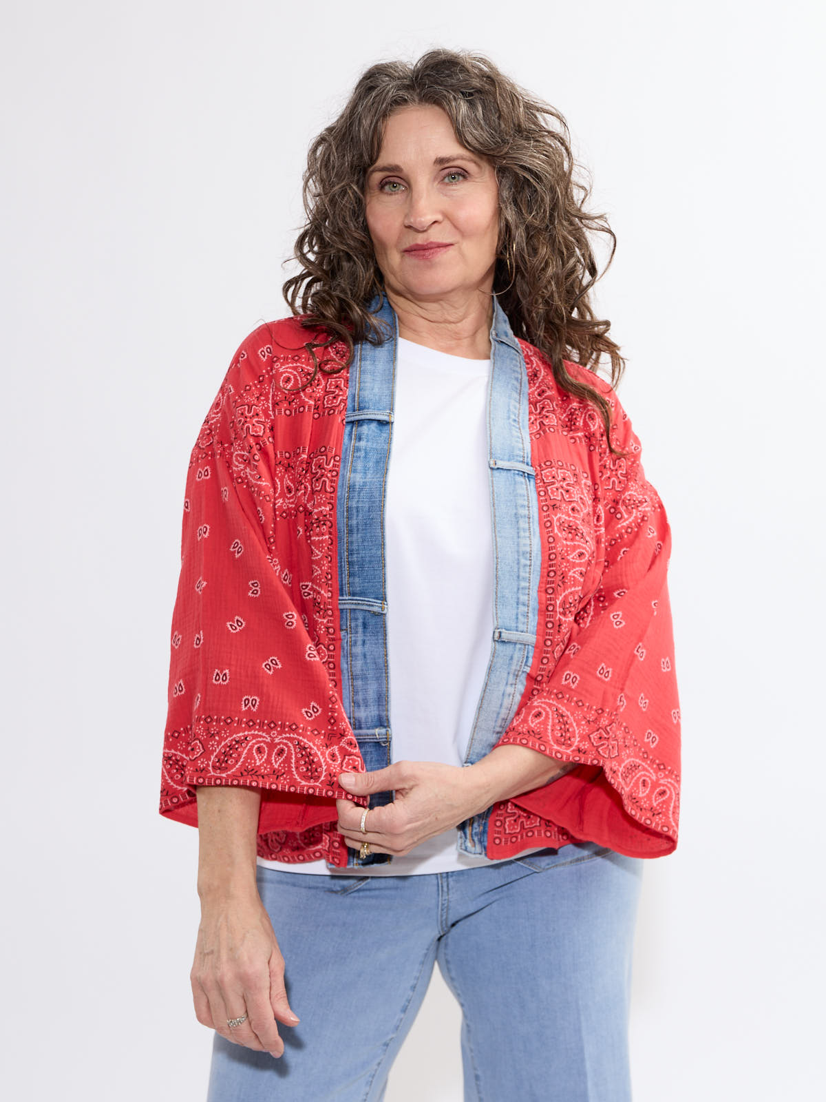Curly-haired model in a red Shannon Passero Bandana Short Kimono over denim with white top by SHANNON PASSERO INC