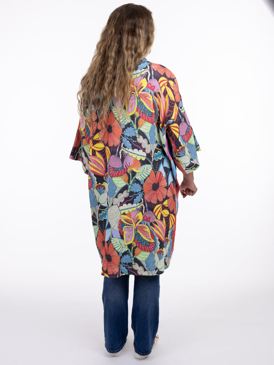 Back view of Shannon Passero Mabel Serendipity Kimono by SHANNON PASSERO INC with multicolor floral pattern and blue jeans.