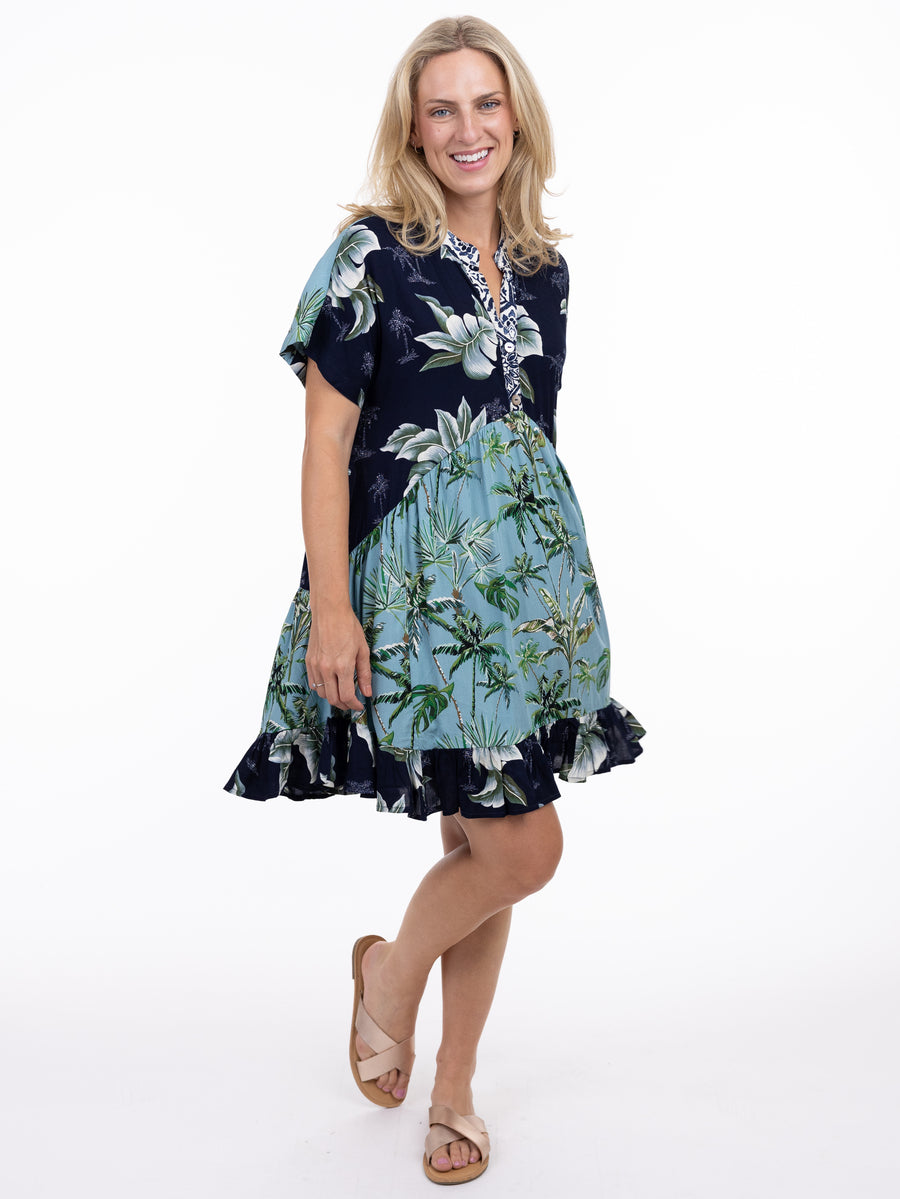 Smiling model in a floral navy and light blue Shannon Passero Coastal Palms Dress by SHANNON PASSERO INC