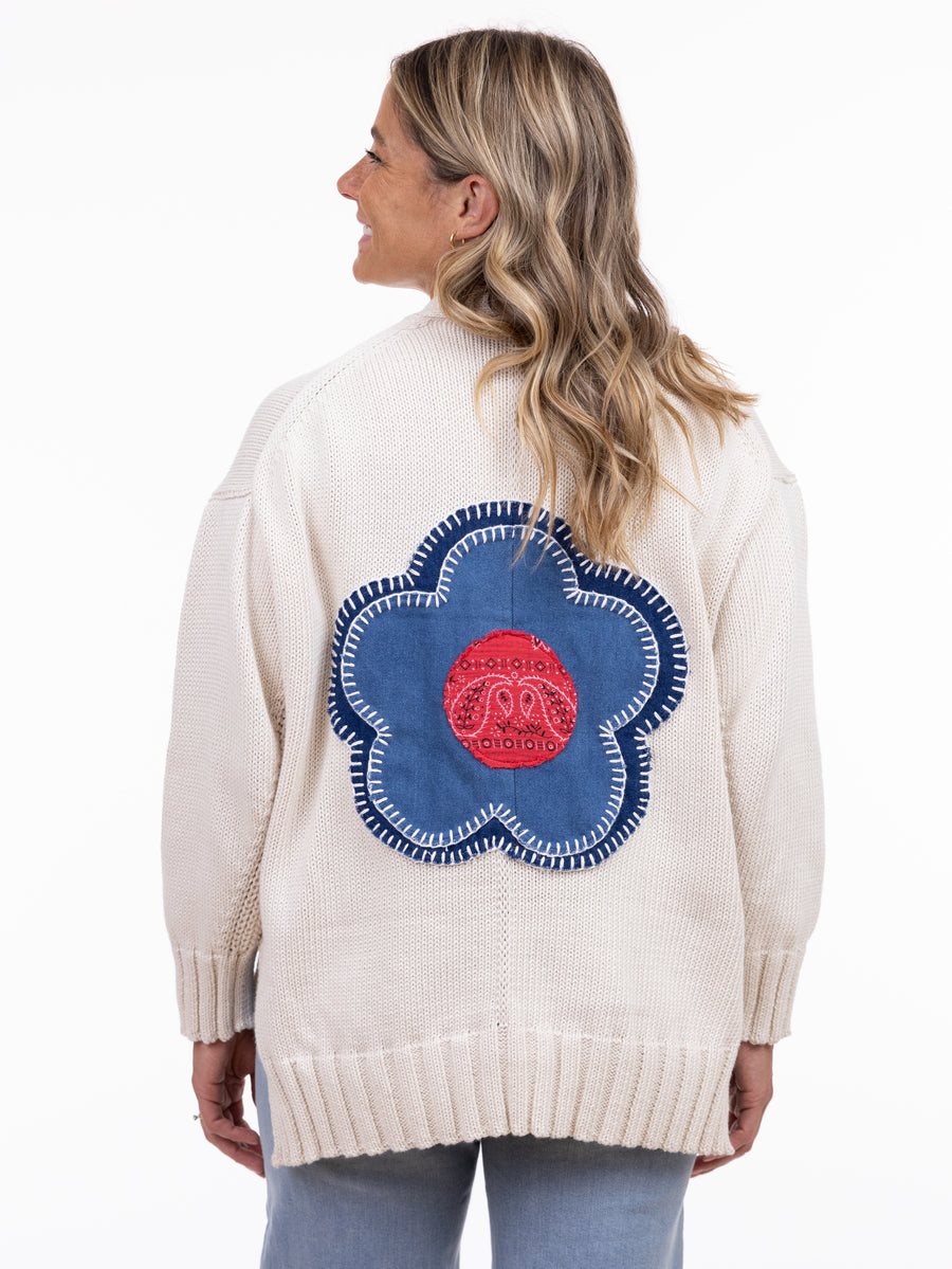 Back view of a cream sweater with a large blue and red flower patch by SHANNON PASSERO INC, Shannon Passero Groove Back Flower Pocket Cardigan
