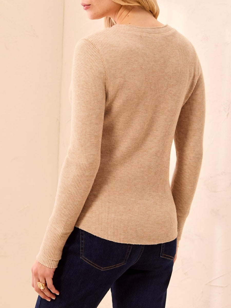 Beige waffle-knit long-sleeve top paired with dark denim jeans, shown from the back and side angle.